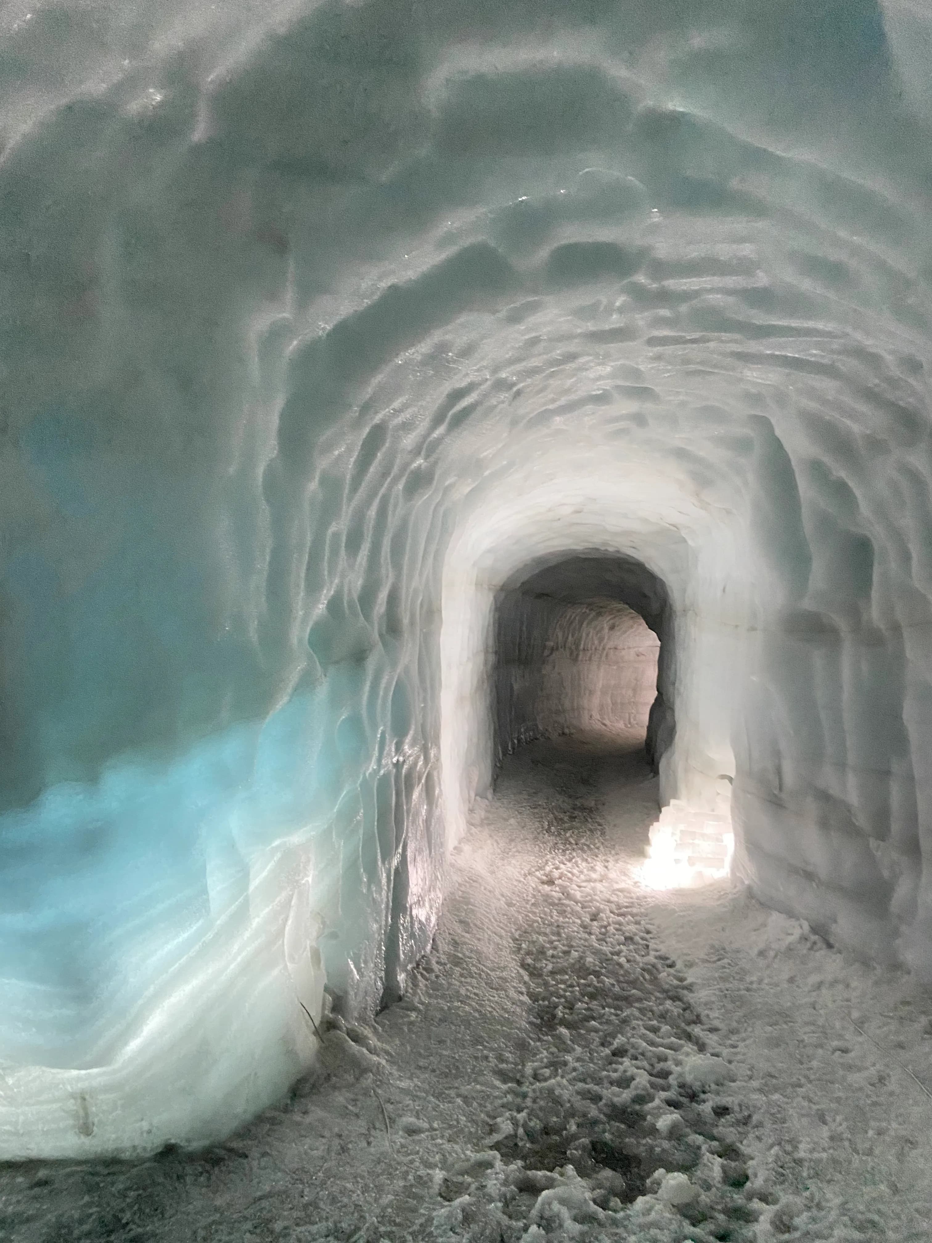 The blue-lit interior of a glacier ice cave in Iceland