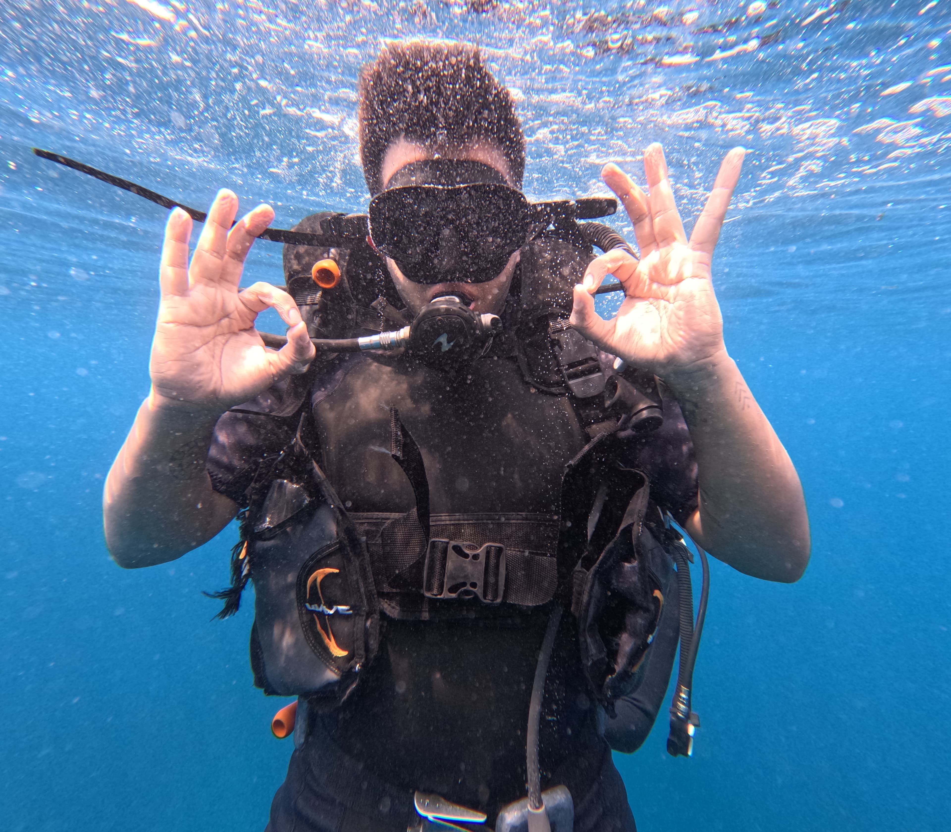 A diver giving an OK sign underwater in Indonesia